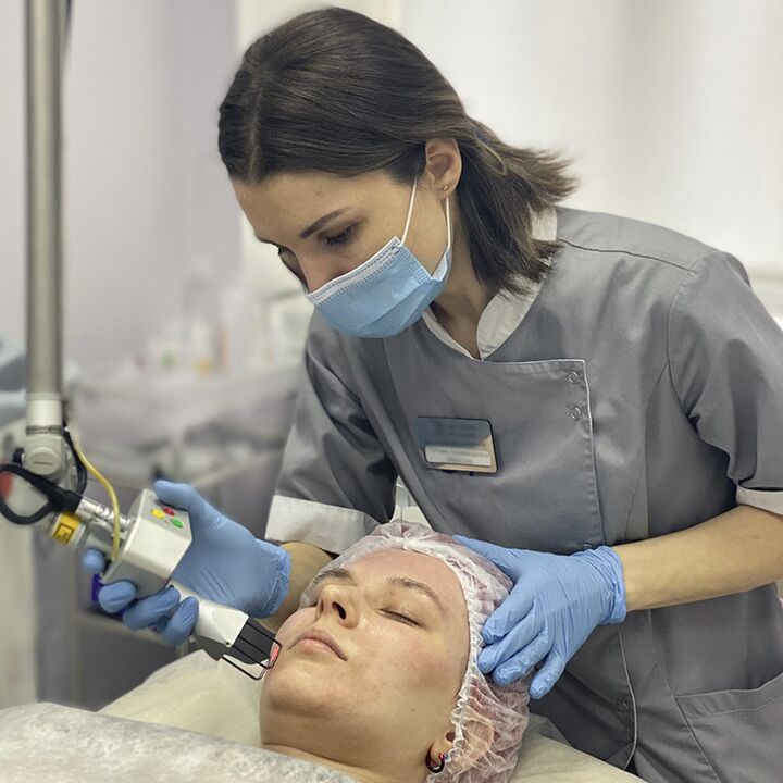Una cosmetóloga realiza un procedimiento de rejuvenecimiento facial fraccionado con láser
